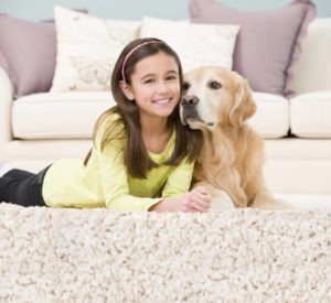 girl and dog on rug